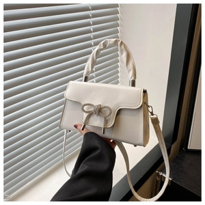 Detailansicht der weißen Ledertasche mit einer glitzernden silbernen Strass-Schleife