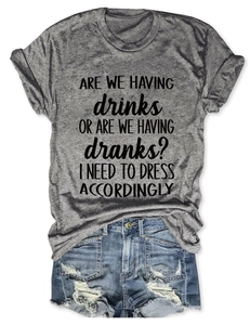 Detail of grey crewneck T-shirt with black slogan paired with ripped denim shorts