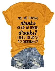 Detail view of yellow cotton t-shirt with slogan and distressed denim shorts on white background