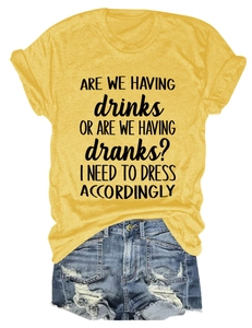 Detail of yellow round neck t-shirt with black text and distressed blue denim shorts