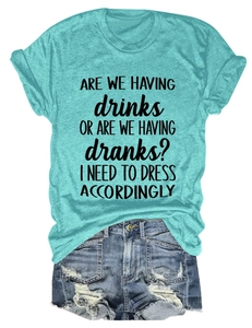 Flat lay of a turquoise round neck t-shirt with humor text and distressed denim shorts