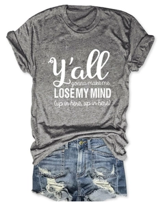 Flat lay detail of a gray crewneck T-shirt with white text and ripped denim shorts