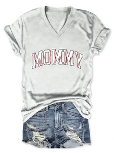 Flat lay of a white V-neck T-shirt with mommy baseball print and ripped denim shorts