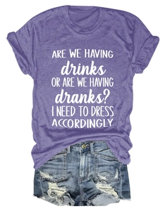 Flat lay of purple crewneck T-shirt with white slogan paired with distressed denim shorts