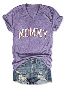Flat lay of purple V-neck T-shirt with MOMMY baseball print and frayed denim shorts