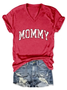 Detail of red V-neck shirt with white MOMMY letters and distressed denim shorts