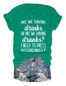 Green crew neck T-shirt with white slogan paired with distressed blue denim shorts