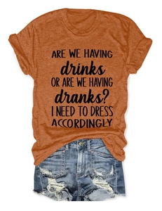 Detail of orange cotton T-shirt with black text print paired with frayed denim shorts