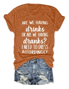 Flat lay of an orange crewneck T-shirt with slogan and ripped denim shorts