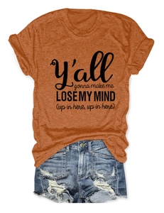 Flat lay of an orange crewneck T-shirt with black text and ripped denim shorts