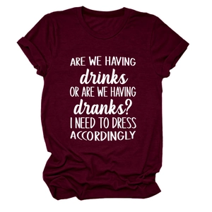 Close-up of funny white text printed on a burgundy cotton crewneck short sleeve t-shirt