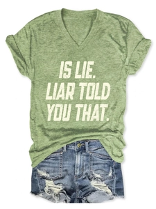 Flat lay of green V-neck T-shirt with white text and ripped denim shorts for summer