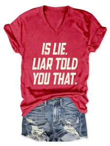 Close-up of red V-neck T-shirt featuring vintage distressed slogan print on fabric