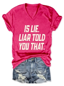 Close-up of pink V-neck t-shirt with text paired with distressed blue denim shorts