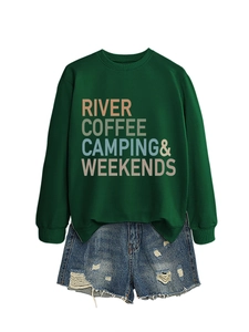 Close-up of River Coffee Camping print on deep green sweatshirt with denim shorts