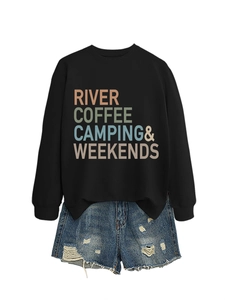 Detail of black pullover sweatshirt with colorful text print and ripped denim shorts