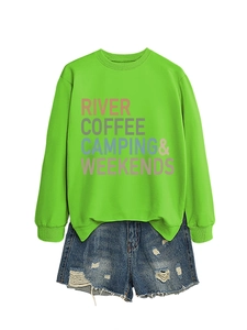 Flat lay of a neon green sweatshirt and distressed denim shorts with outdoor themed print