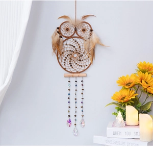 Detail of owl dream catcher with natural brown feathers and clear crystal pendants
