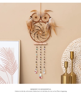 Detail of owl dream catcher with feathers and crystals hanging on a warm cozy wall