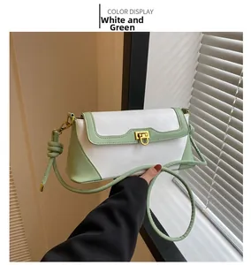 Detail of the white and green color-block shoulder bag with a knotted strap and flap closure