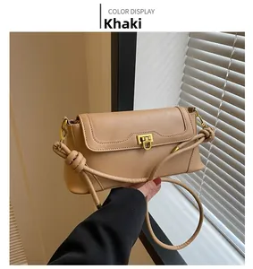 Detailed view of khaki leather shoulder bag with gold clasp and knotted strap detail