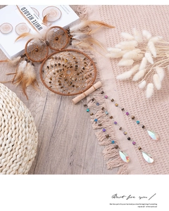 Detail of owl dream catcher with tiger eye stones, brown feathers and crystal droplets