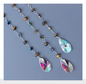 Detailed view of silver chain pendants with Tiger Eye beads and Aurora AB crystal drops