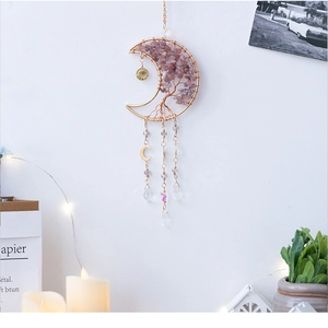 Detail view of pink crystal tree of life moon ornament hanging in a cozy room