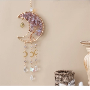 Detail of moon-shaped Tree of Life crystal pendant hanging on wall with purple stones