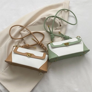 Detail of minimalist baguette bags with retro gold metal buckles and knotted straps