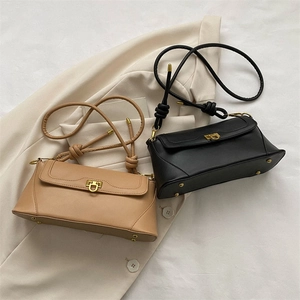 Detailed view of the golden U-shaped clasp and knotted strap on French retro baguette bags
