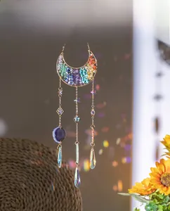Detail of moon suncatcher casting colorful rainbow light reflections on a cozy wall