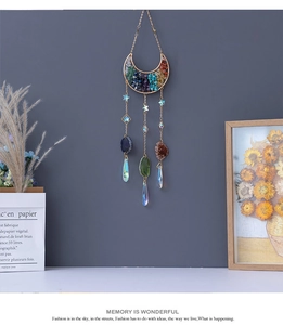 Detail of moon suncatcher with colorful crystals and hanging stones on gold metal frame