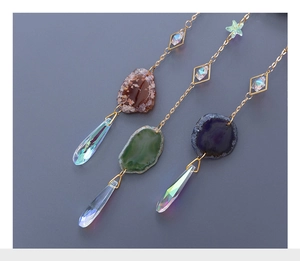 Detail of crystal suncatchers with natural agate slices and teardrop prisms