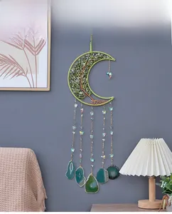 Detail of crystal tree of life dreamcatcher with green agate slices on a grey wall