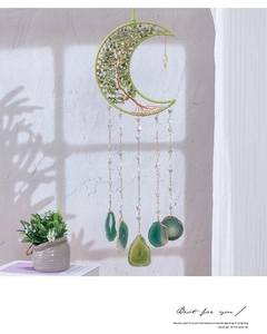Detail of moon-shaped crystal dream catcher with tree of life and green agate slices