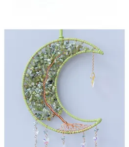 Detail of moon-shaped tree of life dreamcatcher with green stones and butterfly charms