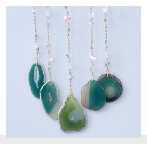 Detail of bohemian life tree decor with natural green agate slices and butterfly beads