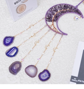 Macro detail of moon-shaped amethyst wire-wrapped tree wall decor with agate slices