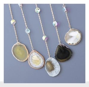 Detail of five natural agate stone pendants with gold chains and colorful crystal beads