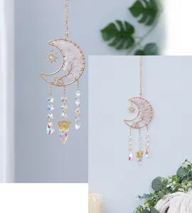 Close-up of handmade rose quartz tree of life moon ornament with sun and crystal charms