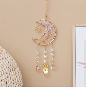 Detail of pink crystal Tree of Life inside a moon frame with sparkling star pendants