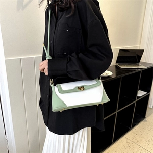 Retro cream and green baguette shoulder bag with gold hardware shown on a model
