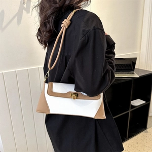 Minimalist French baguette bag in white and brown leather shown on model shoulder