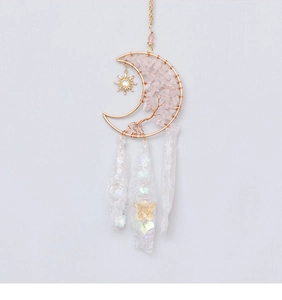 Detail of pink crystal moon tree of life hanging ornament with gold metal sun pendant