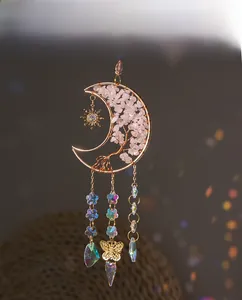 Detailed view of Tree of Life hanging charm with pink quartz crystals and moon frame
