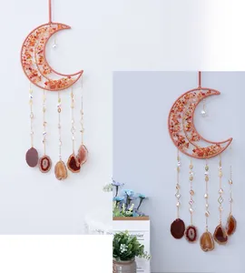 Detail of moon-shaped dream catcher with red agate stones and natural agate slices