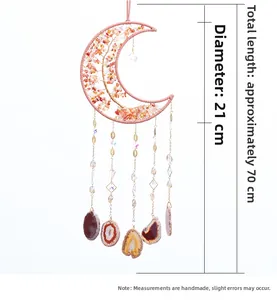 Macro detail of moon-shaped crystal wall hanging with pink threads and agate slices