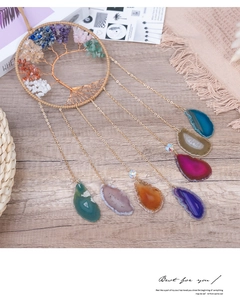 Detail of life tree wall hanging with seven chakra natural agate slices on wood background