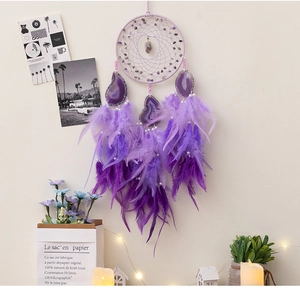 Macro shot of purple agate slices and ombre feathers on a bohemian dream catcher
